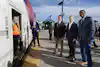 a group of men standing in front of a train