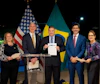 a group of people standing at a podium holding papers