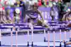 a woman jumping over bars