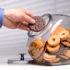 a hand holding a cookie in a jar