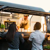 Young people buying meal from street food truck - Modern business and take away concept