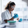 a woman wearing protective glasses and gloves holding a tube