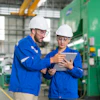 Warehouse workers looking at information on tablet