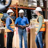 a group of men in hard hats in a warehouse