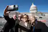 a group of people taking a selfie in front of a white building