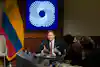 a man in a suit speaking into microphones