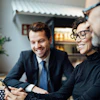Businesswoman showing colleagues something interesting on their phone.