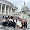 a group of people posing for a photo in front of a building