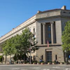 a large stone building with columns and a flag on the front