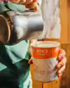 a person pouring milk into a cup