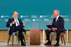 Two individuals in suits engage in a discussion on a stage at a "Building for Growth" event sponsored by the U.S. Chamber of Commerce Housing Policy.