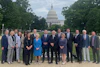 a group of people posing for a photo in front of a capitol building