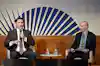 two men sitting in chairs with microphones