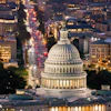 a large white building with a dome and a city street at night