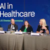 a group of people sitting at a table with microphones
