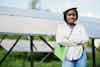 young Black woman in front of solar panels