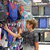 Boy looking for backpacks at the stationery shop