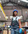 a woman wearing a hard hat and overalls