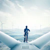 a man standing on a plane with wind turbines in the background