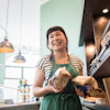 a woman smiling at a bakery