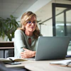 a woman sitting at a desk with a laptop