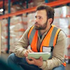 a man in a safety vest holding a tablet