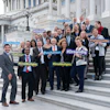 Small business owners stand on the Capitol Steps smiling after visiting with members of Congress