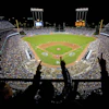 a baseball stadium with people pointing at the field